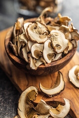 Dried porcini mushrooms. Sliced boletus in bowl on cutting board.