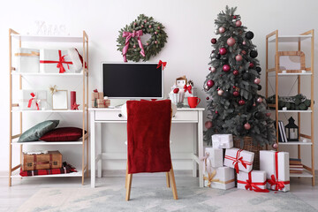 Interior of office with workplace, computer monitor and Christmas presents