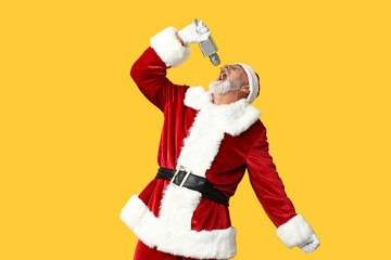 Santa Claus in glasses with microphone singing on yellow background