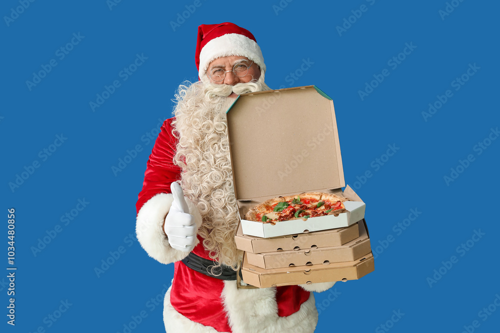 Wall mural Santa Claus with boxes of tasty pizza showing thumb-up on blue background