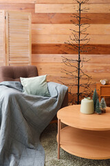 Interior of cozy bedroom decorated for Christmas with armchair and table