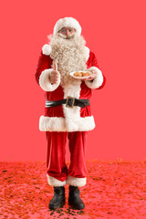 Santa Claus with tasty falafel balls showing thumb-up on red background