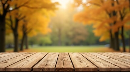 A wooden table is positioned in the foreground of the image, while the background presents a quintessential autumn scene featuring a pathway that traverses a park environment.	