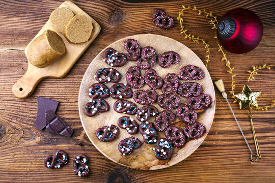 Home made marzipan pretzel cookie confection sweets glazed im dark chocolate served as top view with ice sugar topping
