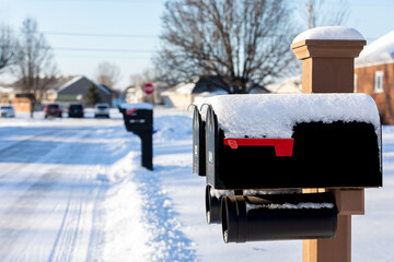 Snow covered mailbox after winter storm. Winter weather and postal mail delivery concept.