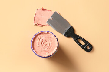 Knife with putty on beige background