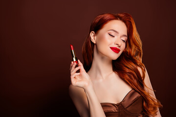 Obraz premium Photo of stunning lovely lady advertising cosmetics maquillage red pomade isolated on brown color background