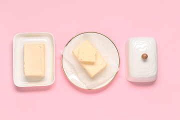 Plate and dish with fresh butter on pink background