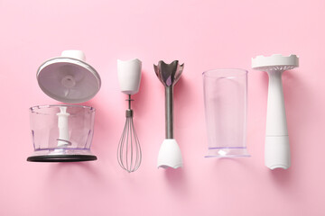 Modern blender with different attachments on pink background