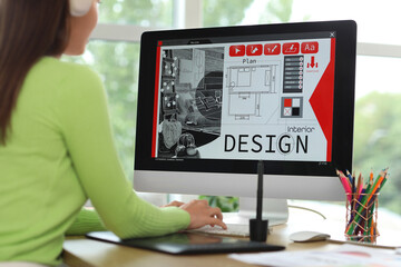 Young female graphic designer working with computer at table in office, closeup