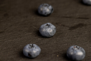 blueberries scattered on a black slate board