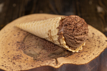 chocolate ice cream in a cone on a board