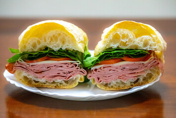 Italian mortadella bologna sandwich with arugula, tomato and cheese on ciabatta bread