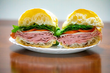 Italian mortadella bologna sandwich with arugula, tomato and cheese on ciabatta bread