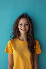 Fototapeta premium Clothing Model Wearing a Blank Yellow T-shirt Standing in Front of a Blue Background, Print on Demand Template, Fashion Portrait Mockup, People Wearing Tee Shirt with Print Copy Space