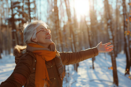 senior woman with outstreched hands in winter outdoors. Happy retirement days. High quality photo