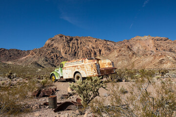 Abandoned vintage rusted vehicle in a desert junkyard
