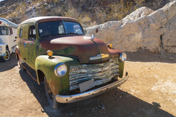 Abandoned vintage rusted vehicle in a desert junkyard

