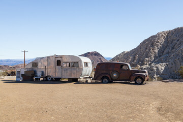 Abandoned vintage rusted vehicles in a desert junkyard
