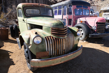 Abandoned vintage rusted vehicles in a desert junkyard
