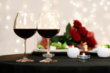 Romantic Evening. Affectionate couple dating in restaurant, two glasses with red wine in foreground, selective focus
