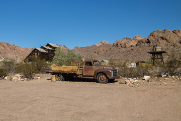 Abandoned vintage rusted vehicle in a desert junkyard
