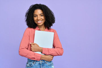 Happy young African American girl student holding laptop standing isolated on purple background, smiling female professional model employee working on computer device. Portrait.