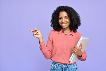 Happy young African college student model holding copybooks isolated on purple background. Smiling...