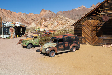 Abandoned vintage rusted vehicles in a desert junkyard
