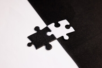 Opposite day concept using white and black puzzle pieces with oposite background color. Similar to...