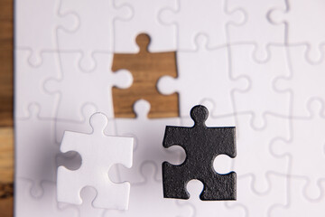 Fototapeta premium Conceptual image using a blank puzzle and a white and black puzzle piece that both fit the missing hole.