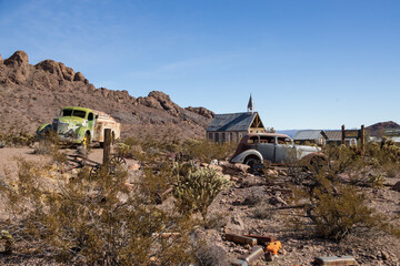 Abandoned vintage rusted vehicles in a desert junkyard
