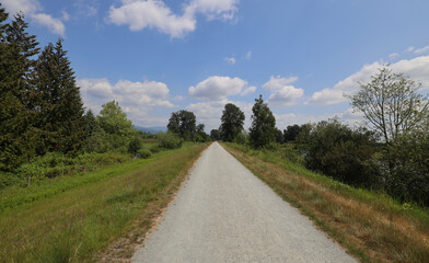 Perspective of gravel road on river dykes