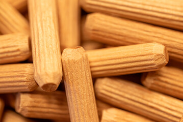 A pile of wooden dowels with a grainy texture. The pile is made up of many different sizes and shapes