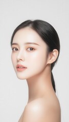 Obraz premium Elegant portrait of an attractive woman with flawless skin, subtle makeup, and a serene expression on a light background.