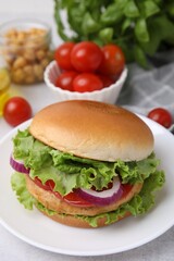 Delicious vegetarian burger with chickpea cutlet and ingredients on light table, closeup