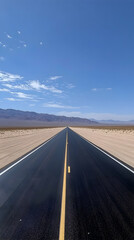 Fototapeta premium Long Straight Highway Cutting Through a Vast Desert Landscape Under Clear Blue Sky