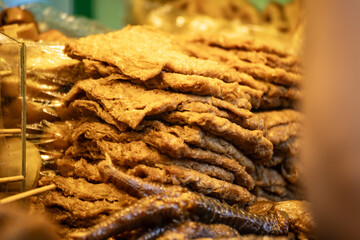 a stack of braised tofu skin at a food stall. These tofu skins are neatly piled together, highlighting their texture and color.