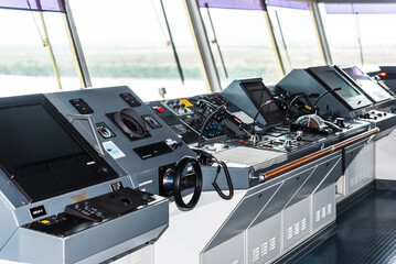 View of the control console on the navigational bridge of the cargo container ship. 