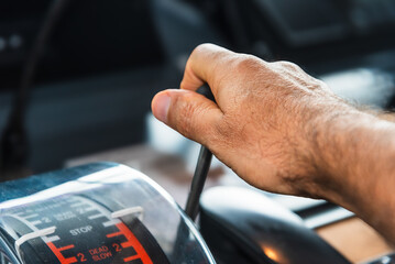 The hand of an operator grips the engine telegraph lever on the bridge of a merchant ship, ready to...