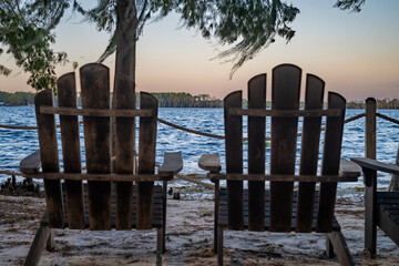 Two Adirondack chairs sit quietly by the lake, offering a perfect spot to relax and take in the...