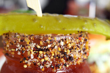 Caesar cocktail close up. Bloody Mary with spices and pickle in mason jar or drinking glass. Happy hour concept. Also known as Bloody Caesar. Cocktail with vodka and tomato juice. Selective focus.