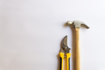 Metal hammer with wood handle and pruning scissors or garden trimmer with various layouts isolated on a white background.
