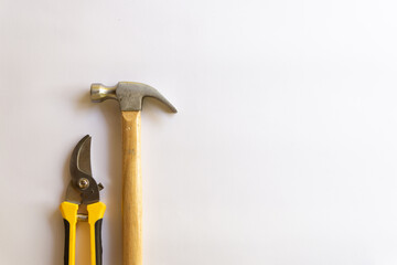 Metal hammer with wood handle and pruning scissors or garden trimmer with various layouts isolated on a white background.