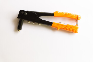 Rivet tool with orange handle and silver blind rivets for hand rivets of various layouts isolated on white background.