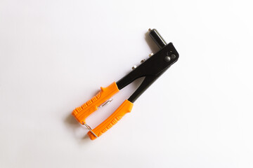 Rivet tool with orange handle and silver blind rivets for hand rivets of various layouts isolated on white background.