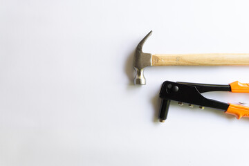 Metal hammer with wood handle and Rivet tool with various layouts isolated on a white background.
