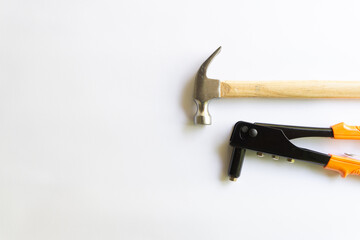 Metal hammer with wood handle and Rivet tool with various layouts isolated on a white background.