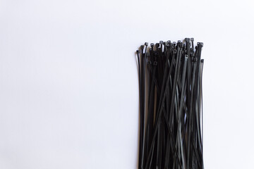 Black plastic cable ties with various layouts isolated on white background.