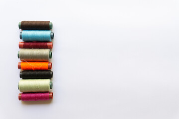 Top view of colorful threads on white background with various layouts.